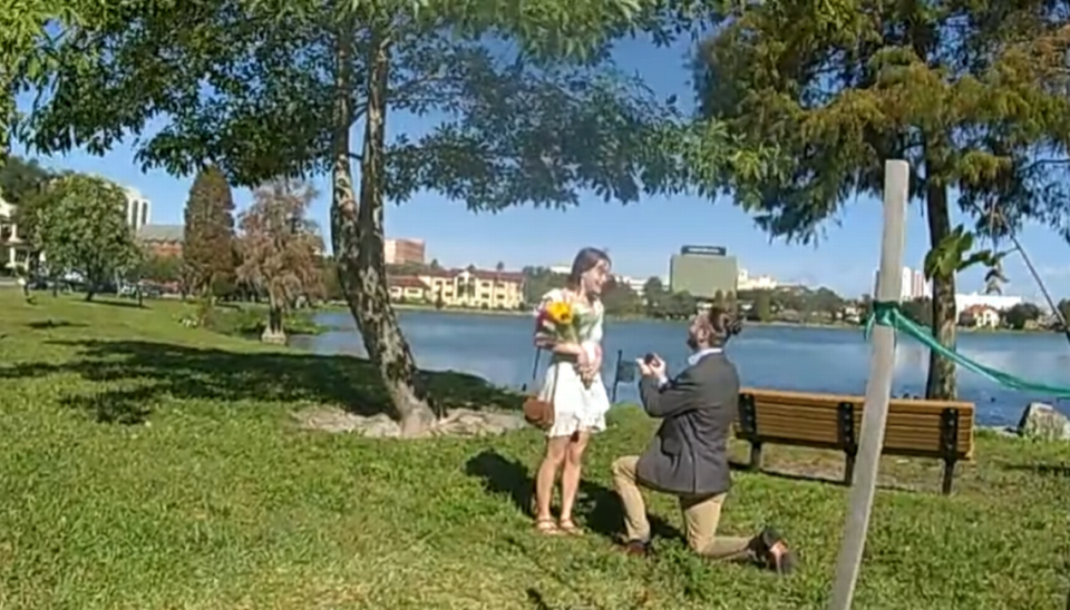 The student led his girlfriend toward the lake on campus, then got down on one knee to ask her to marry him.