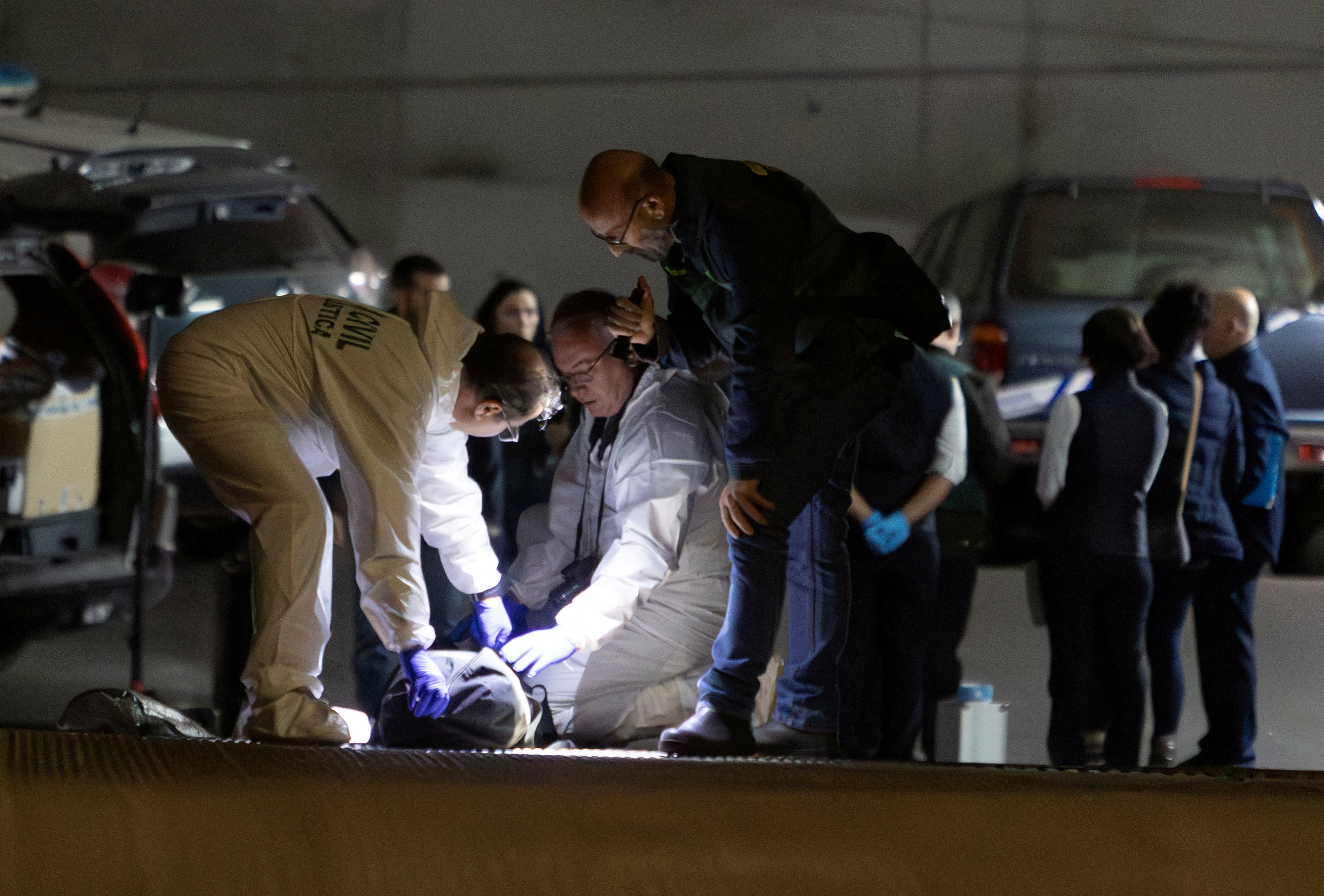 Spanish investigators cover Maxim's body inside the underground carpark