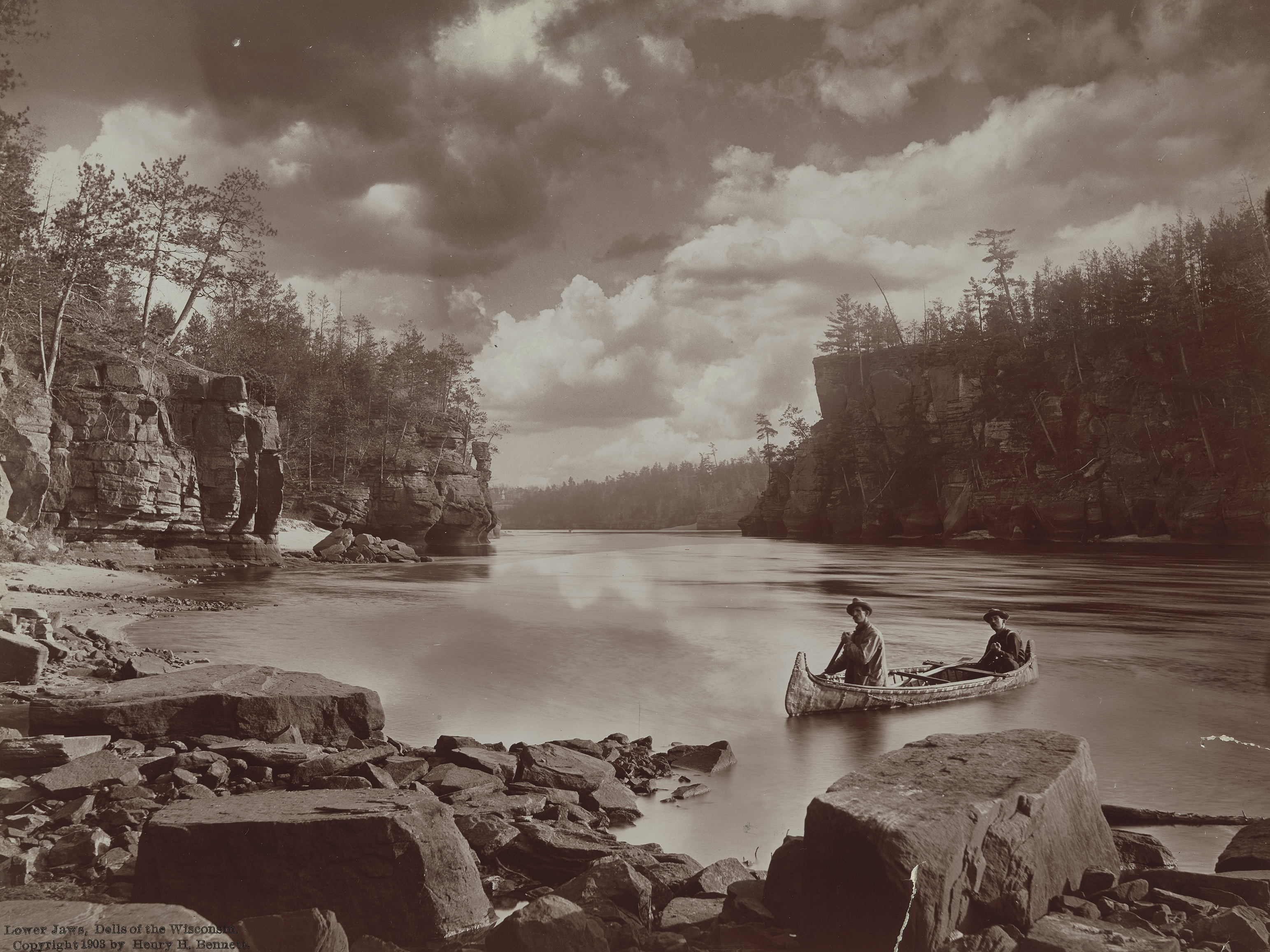 Black and white photo of canoe on lake 